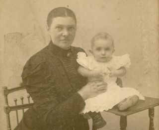 Oude vergeelde foto van vrouw en baby